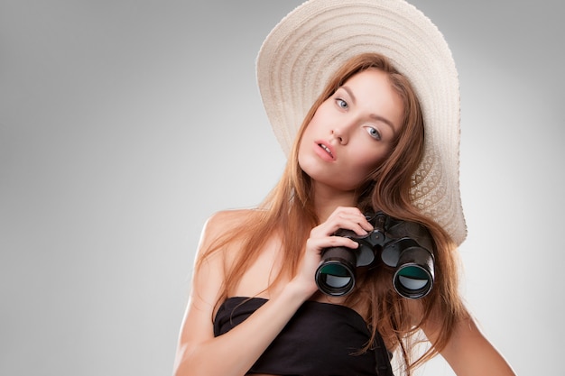 Young woman in hat with binoculars