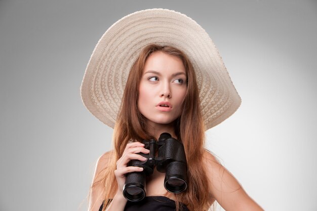 Young woman in hat with binoculars