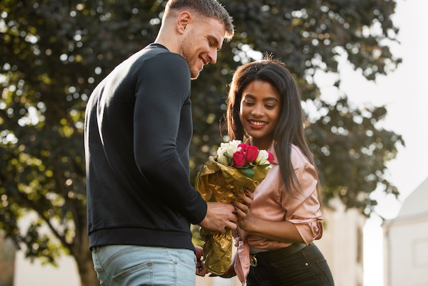 Free photo young woman having a bouquet of roses from her boyfriend