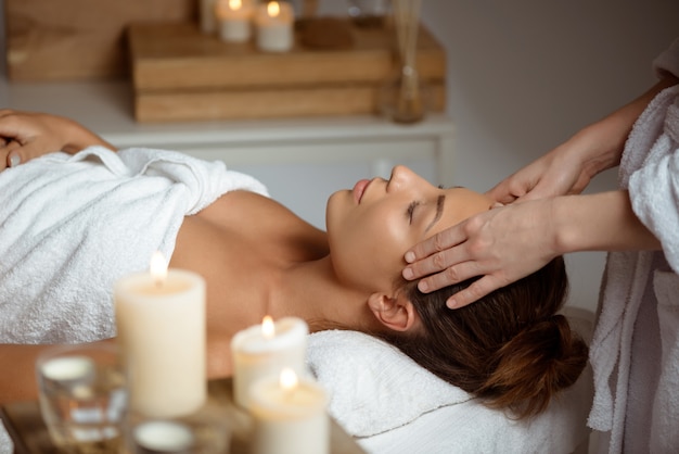 Free photo young woman having face massage relaxing in spa salon.