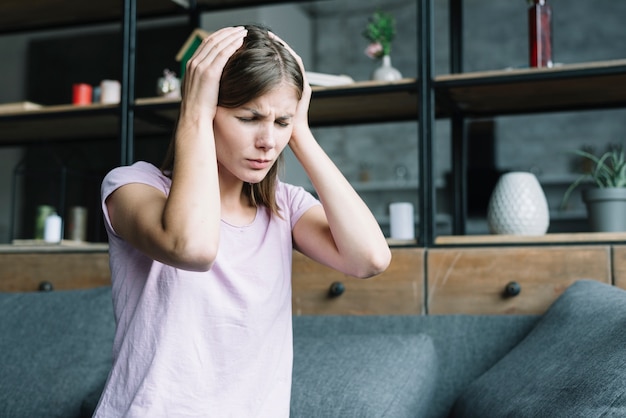 Free photo young woman having headache at home