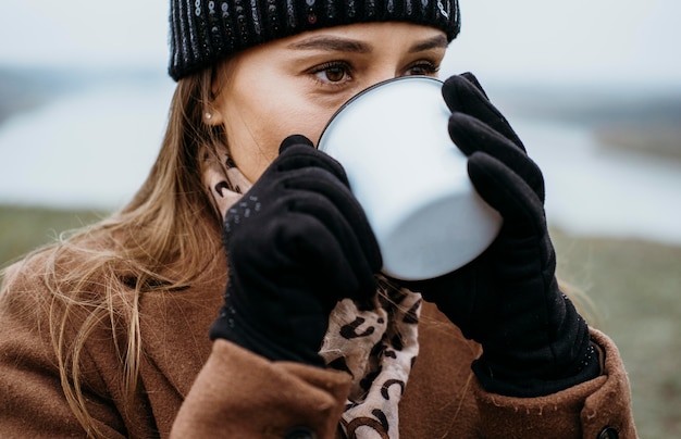 Free Photo young woman having a hot drink outdoors