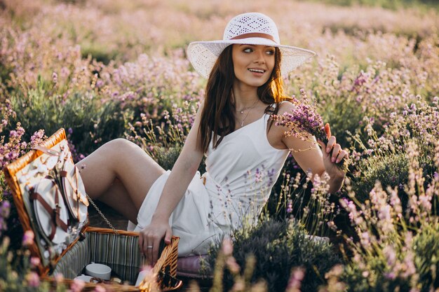 Young woman having picnic in a lavander field