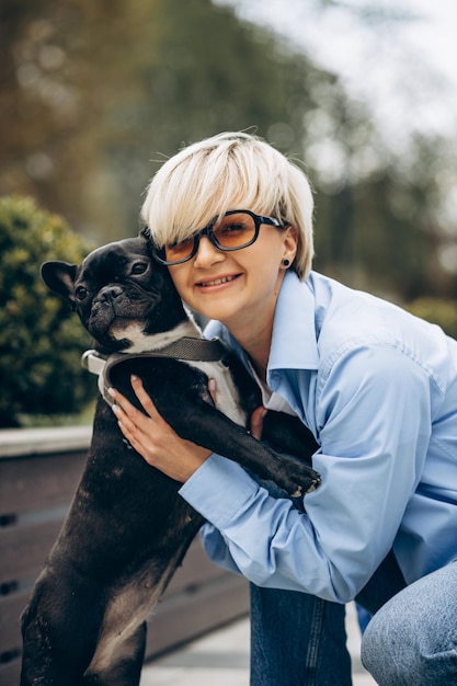 Young woman having a walk with her pet french bulldog