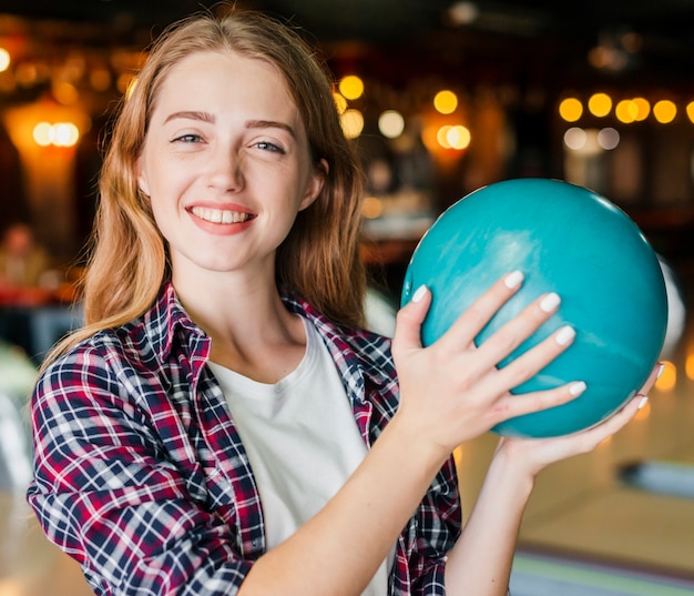 Young woman holding bowling ball