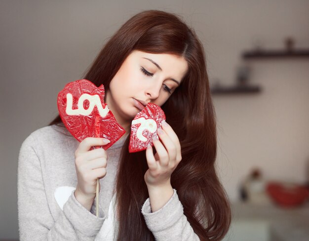 Young woman holding a broken lollipop