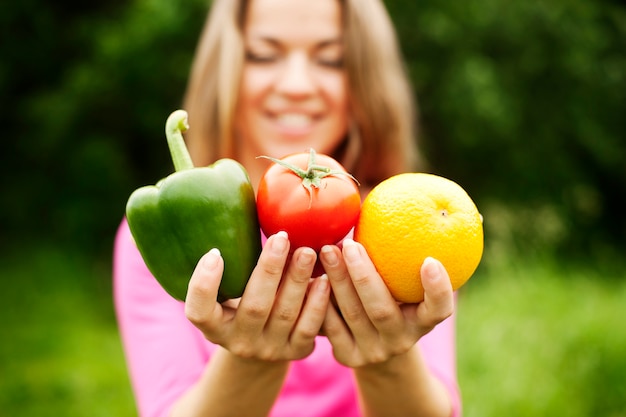 Free photo young woman holding fruits and vegetables