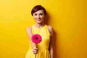 Free photo young woman holding gerbera daisy flower