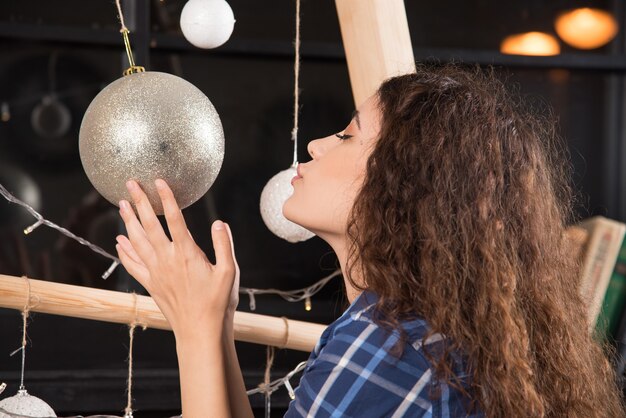 Young woman holding a golden Christmas ball