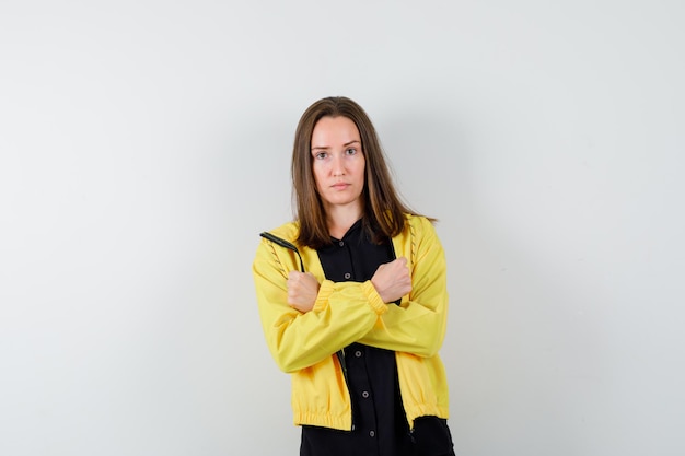 Free photo young woman holding hands crossed and clenching fists