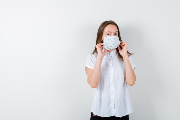 Young woman holding hands on her medical mask