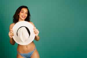 Free photo young woman holding hat