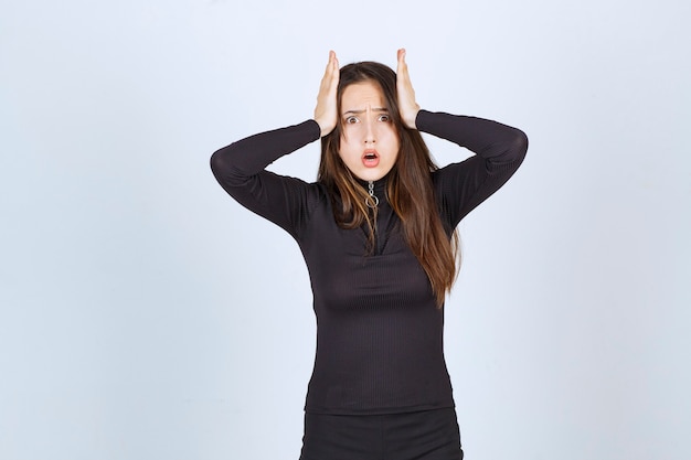 Free photo young woman holding her head as she has headache or got thrilled