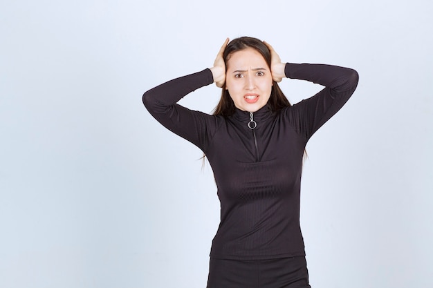 Young woman holding her head as she has headache or got thrilled