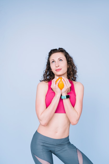 Free Photo young woman holding an orange