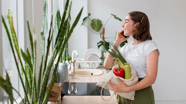 Free photo young woman holding organic vegetables