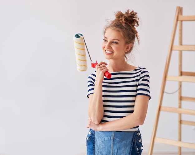 Free photo young woman holding a paint roller