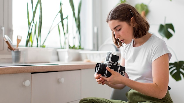 Free photo young woman holding professional camera