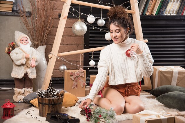 Free Photo young woman holding a red christmas ball