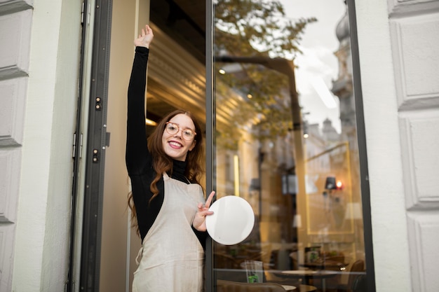 Free photo young woman holding shop sign