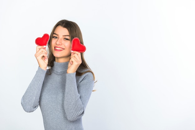 Young woman holding small hearts in hands 