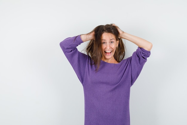 Free photo young woman holding strand in hands in violet shirt and looking crazy. front view.