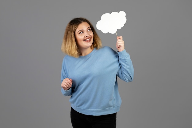 Free Photo young woman holding a thought bubble