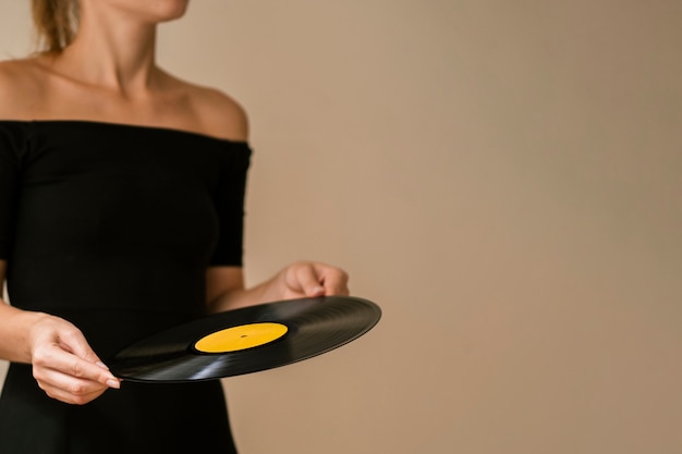 Young woman holding vinyl disk with copy-space