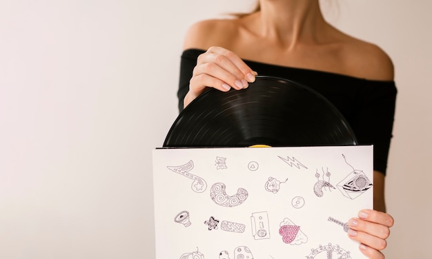 Young woman holding vinyl record in its case