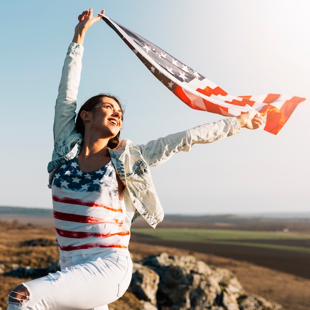 Young woman holding waving flag of America