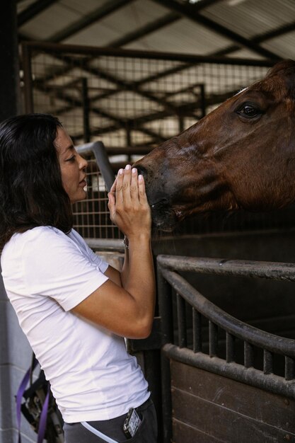 A young woman and a horse, feelings, care, affection, tenderness, a woman hugs and kisses a horse. Close up of happy young woman hugging her horse.