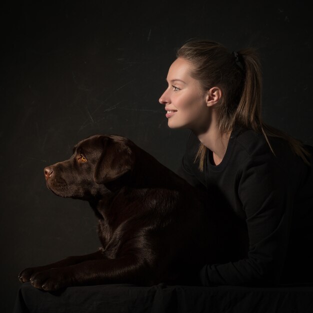 The young woman hugging a mix breed dog