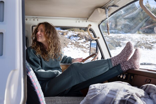 Young woman inside a camper van during winter trip