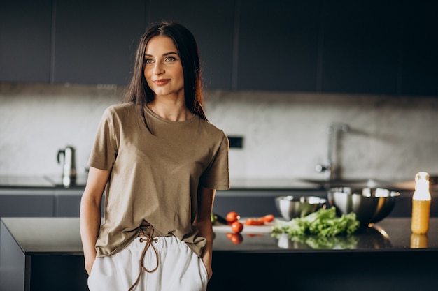 Young woman at the kitchen preparing for dinner