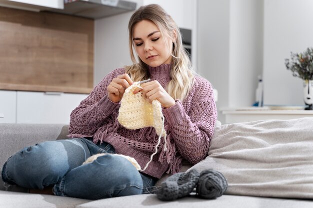 Young woman knitting while relaxing