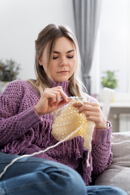 Young woman knitting while relaxing