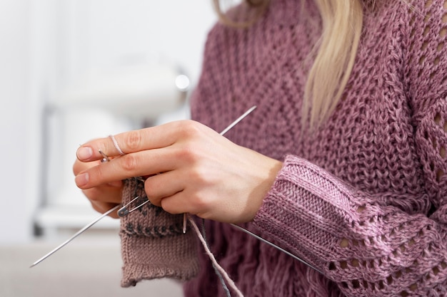 Free photo young woman knitting while relaxing