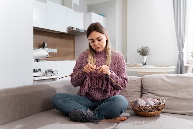 Young woman knitting while relaxing