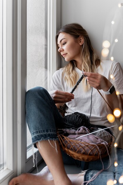 Young woman knitting while relaxing