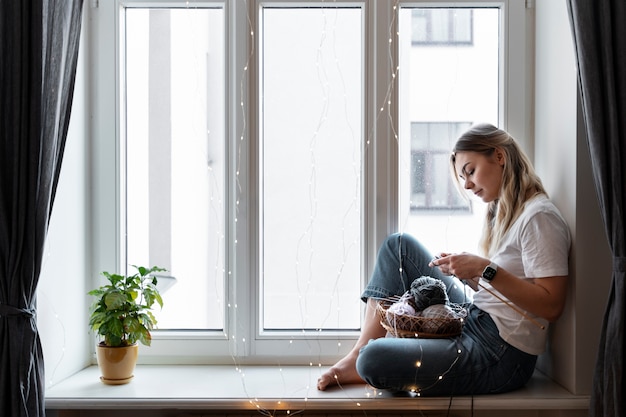 Young woman knitting while relaxing