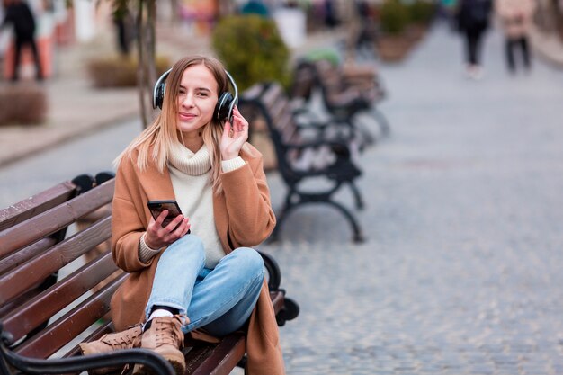 Young woman listening to music on headphones with copy space