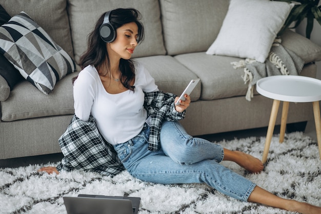 Free photo young woman listening music on headphones