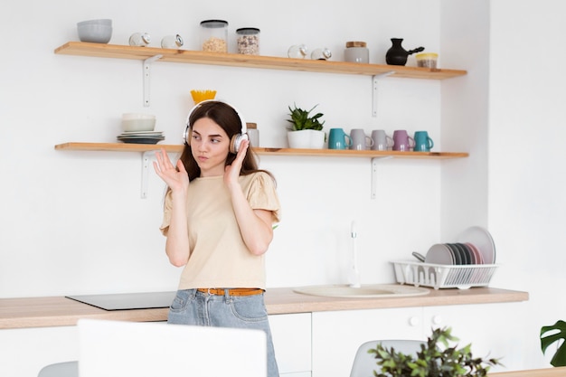 Free photo young woman listening to music through headphones