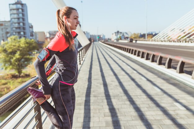 Young woman listening to music while stretching