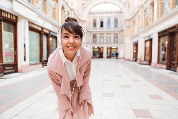 Free photo young woman listening to music with headphones on a city street