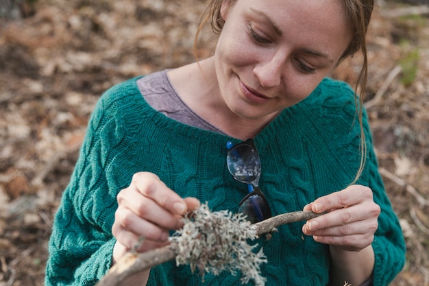 Free photo young woman looking at a branch