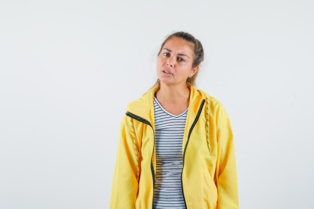 Free photo young woman looking at camera in t-shirt, jacket and looking perplexed. front view.