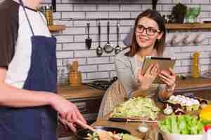 Free photo young woman looking at cooking boyfriend