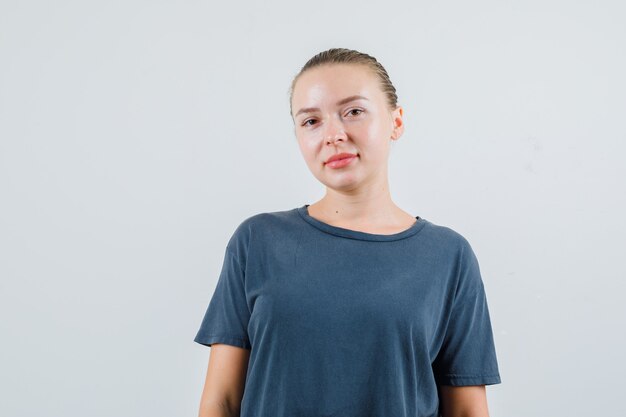 Young woman looking in grey t-shirt and looking positive