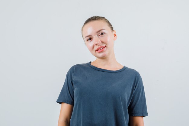 Young woman looking in grey t-shirt and looking positive